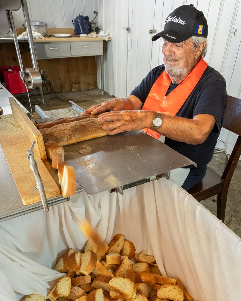 A man uses a jigsaw to cut baguettes for a Festa feast