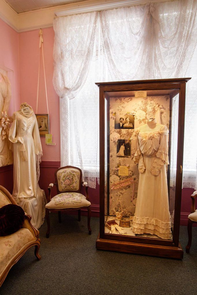 A Victorian wedding dress in a display case