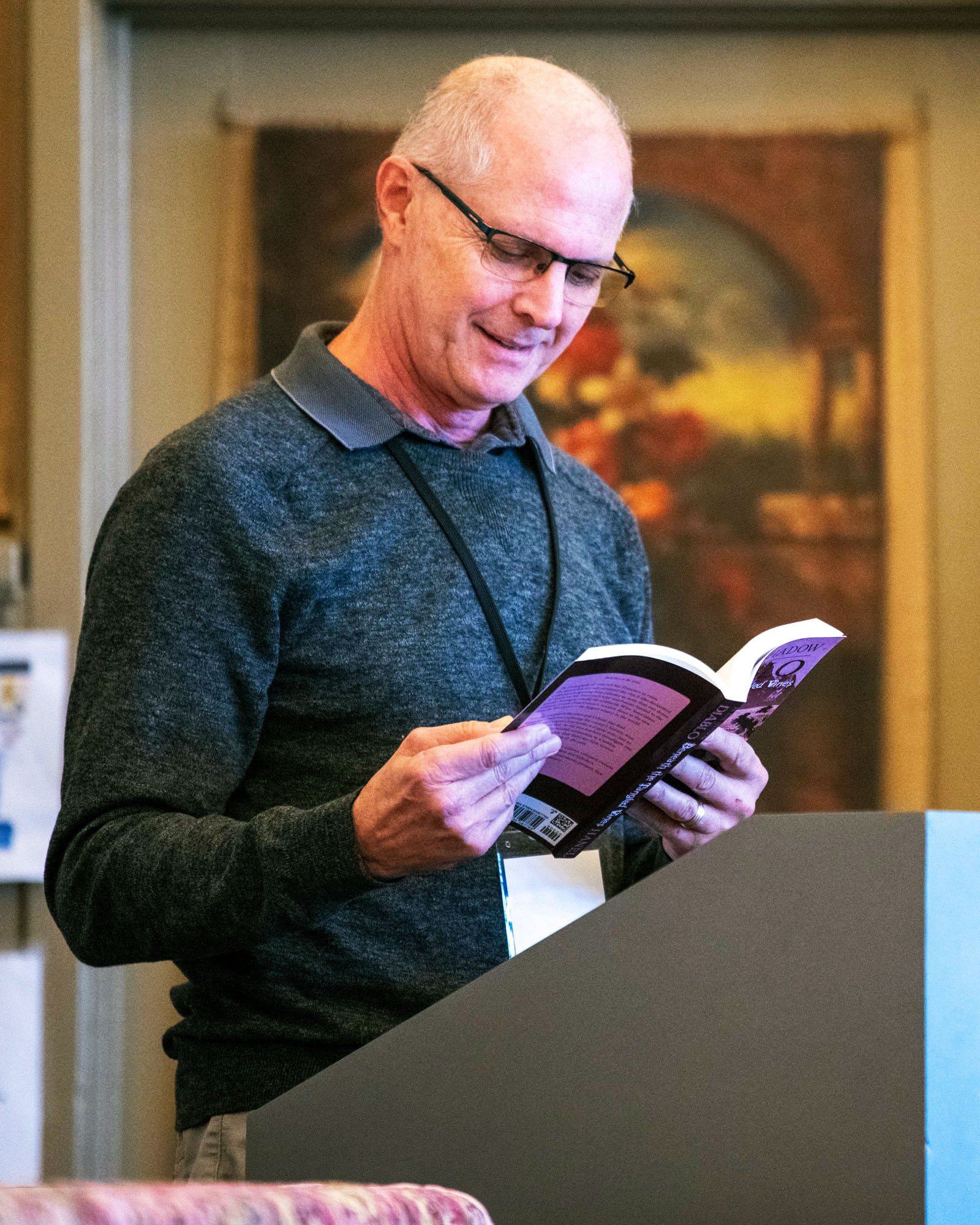 An author at a podium reading from his book