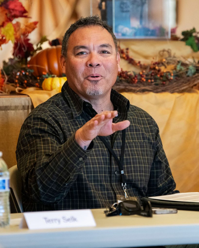 Man gesturing as she speaks to an audience