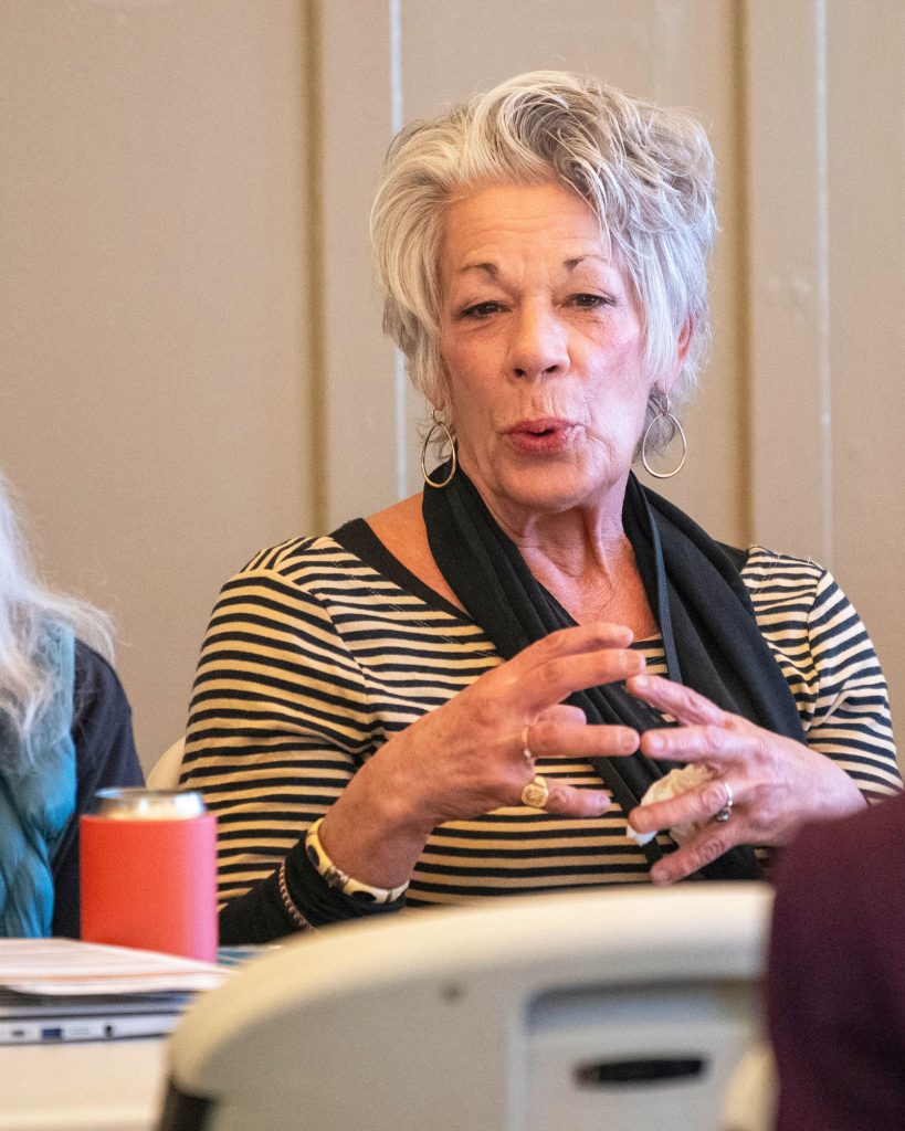 Woman gesturing as she addresses a panel