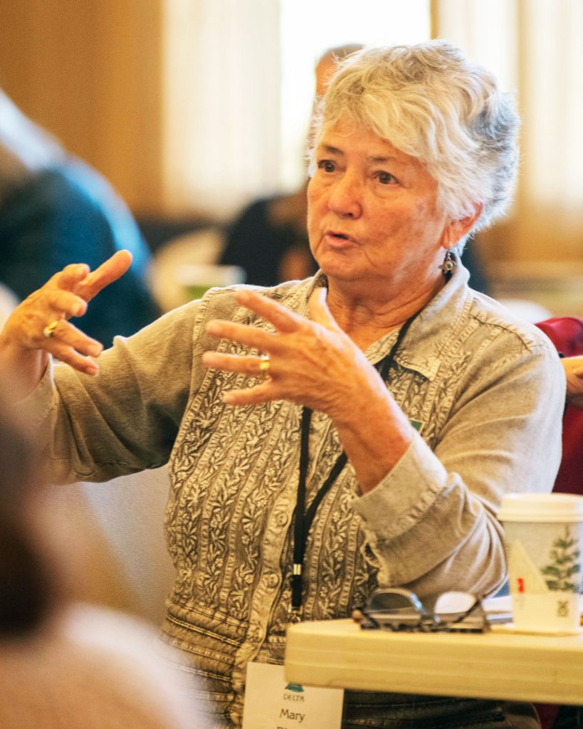 Woman gesturing as she speaks to a panel