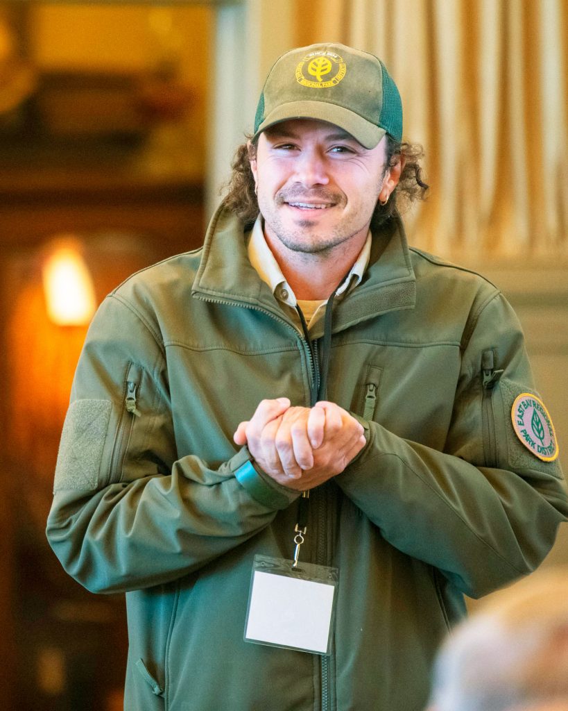 Man clasping his hands while addressing an audience