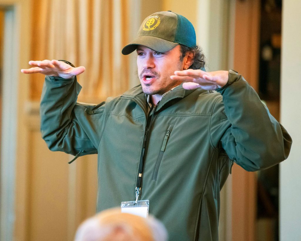 Man gesturing while speaking to an audience