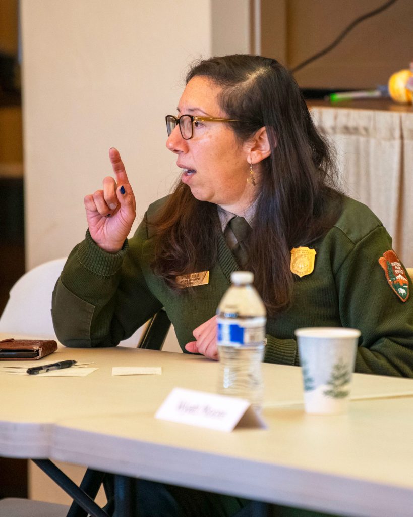 Panelist gesturing as she addresses an audience