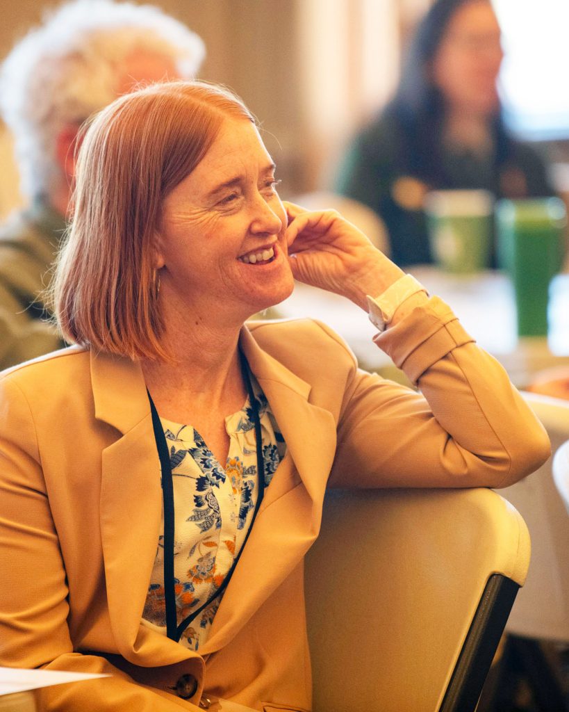 Woman smiling in reaction to a speaker