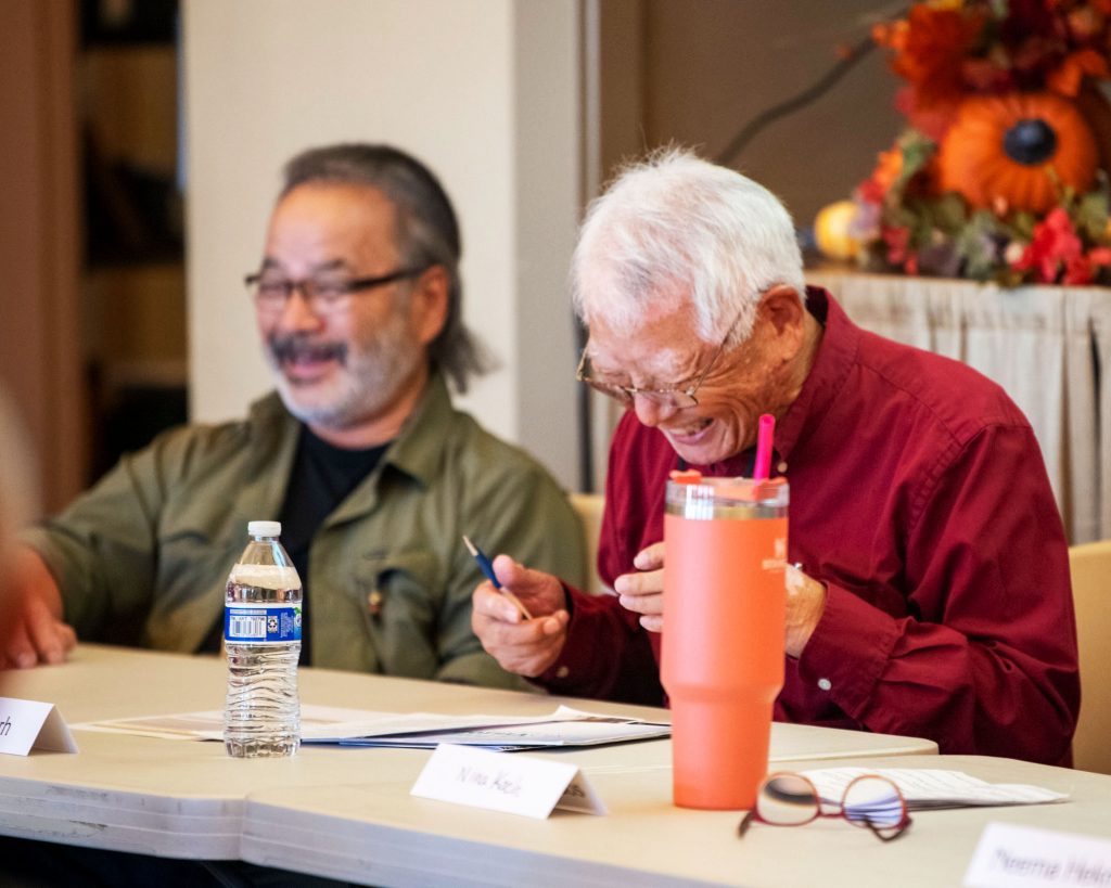 Panelist breaks down laughing while addressing an audience