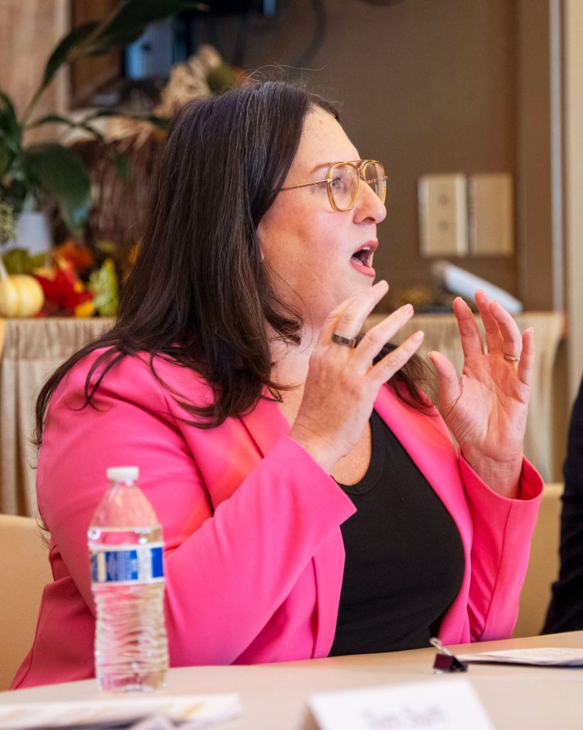 A panelist gestures while speaking to her audience