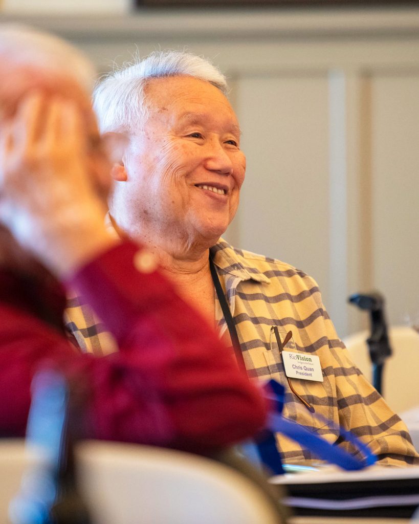 Man smiles in reaction to a speaker