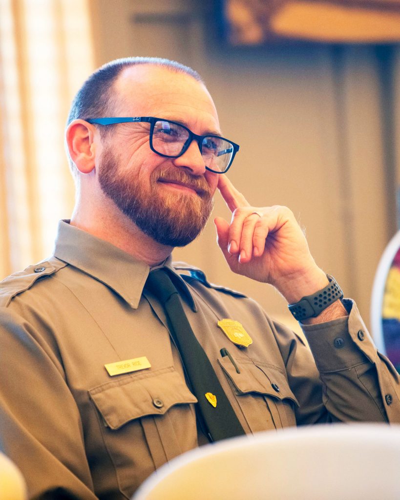 Man smiles in reaction to a speaker