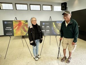 Man and woman standing in front of displays on easels