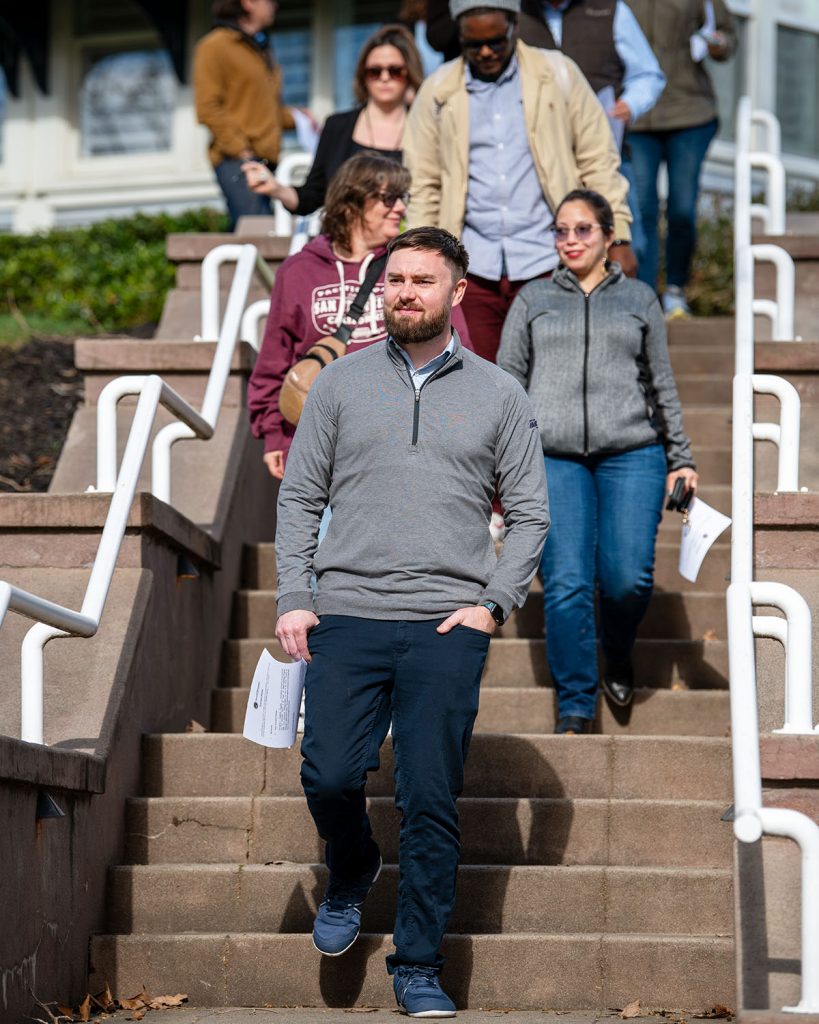 A man walks down steps with a piece of paper in hand