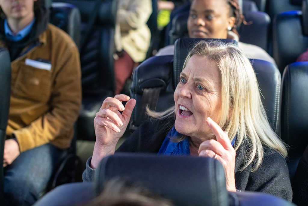 A woman on a bus gesturing as she speaks