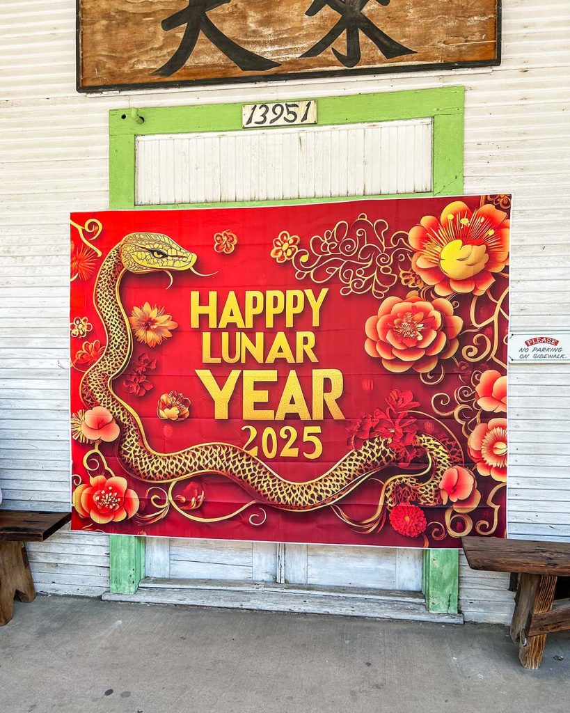 A bright red Happy Lunar New Year 2025 sign