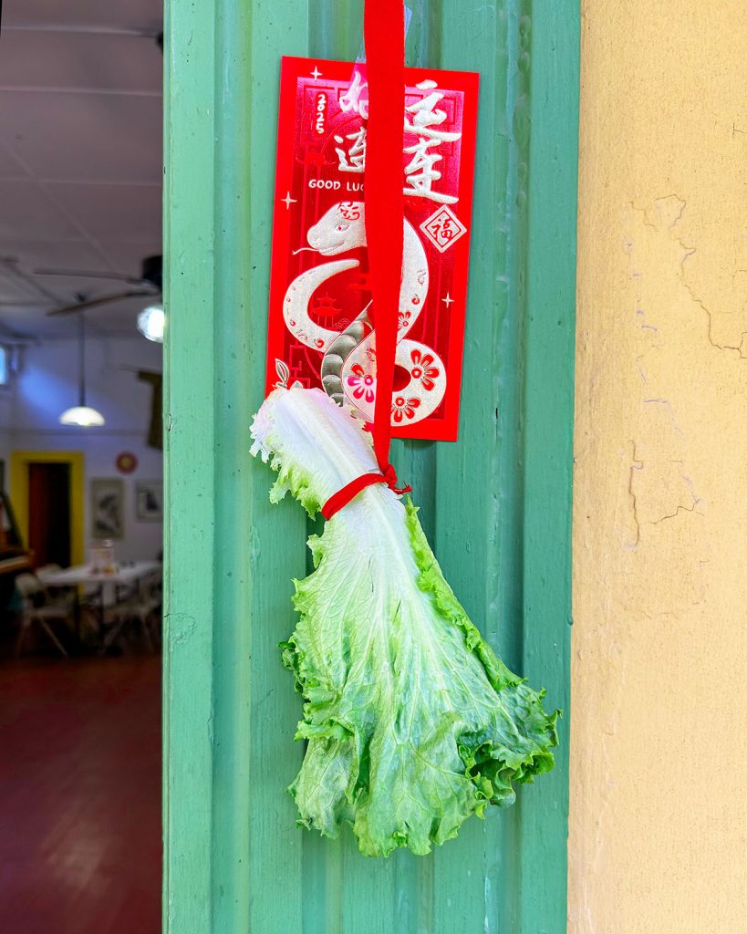 Lettuce hanging from a red ribbon in a doorjamb