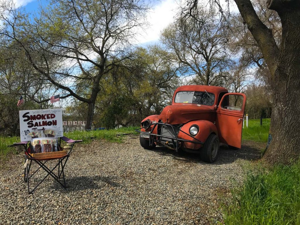 A self-service food stand with an old truck in the background