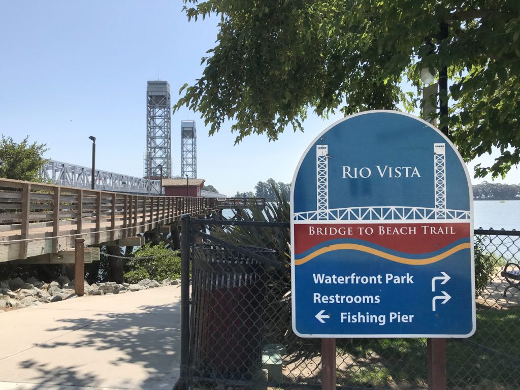 A wayfinding sign with a bridge in the background