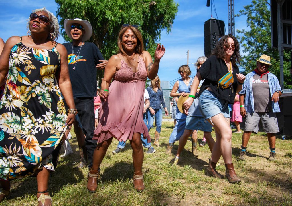 Diverse adults line dancing on a lawn