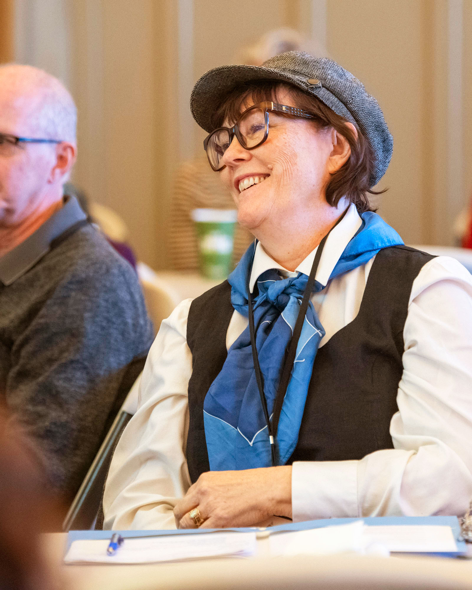A woman seated at a table smiling