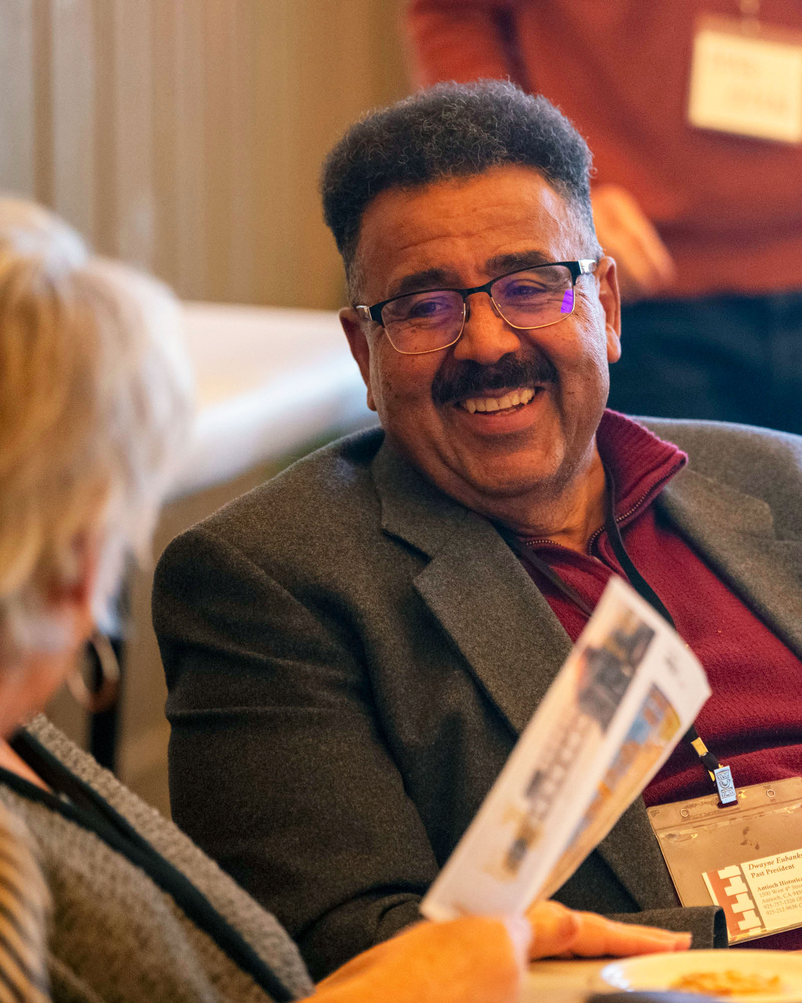 A man smiling at a woman holding a piece of paper