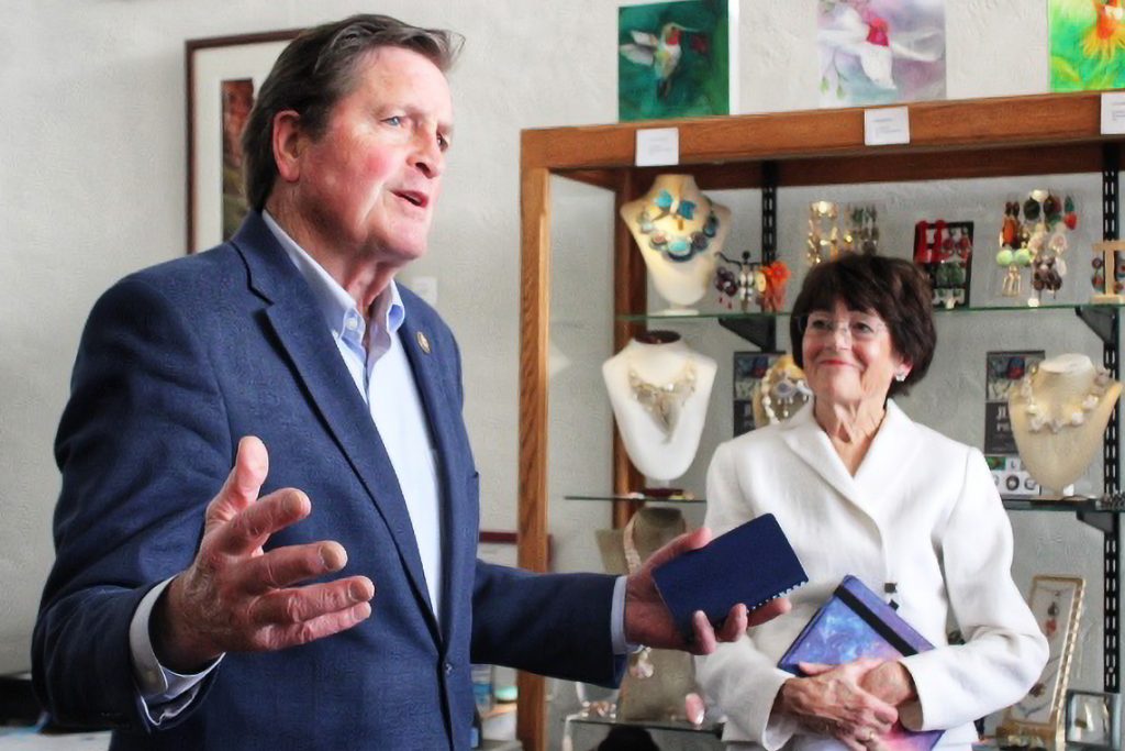 A man gestures while speaking to a gathered audience