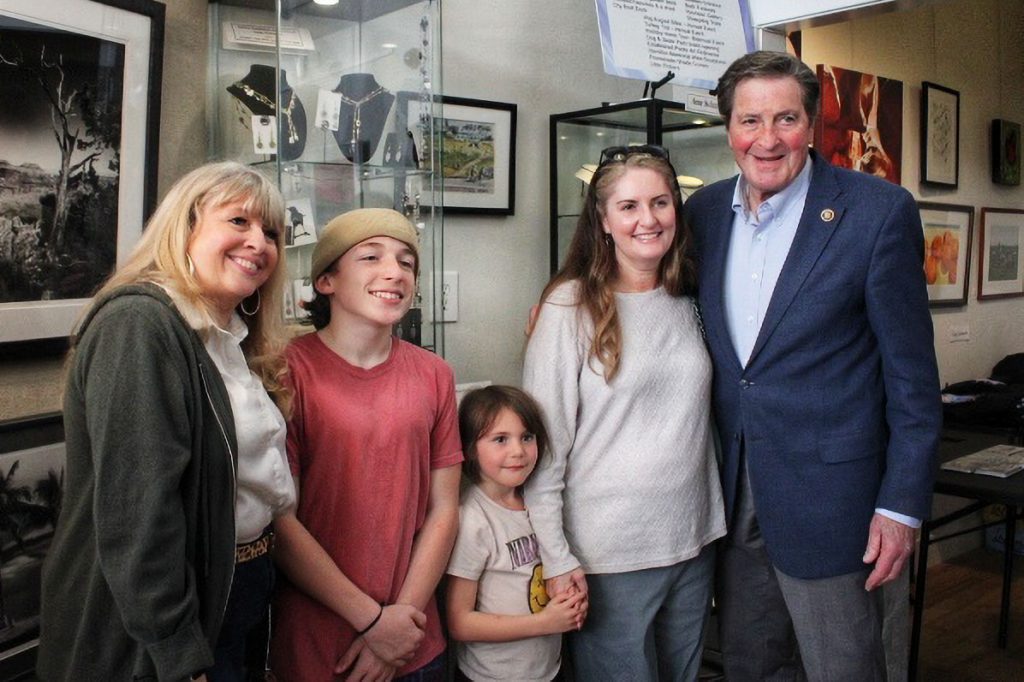 Two women and two children pose with a smiling man