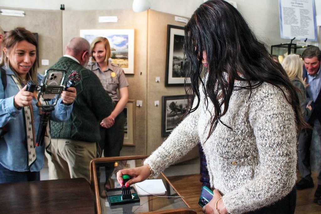 A woman presses a rubber stamp into an inkpad