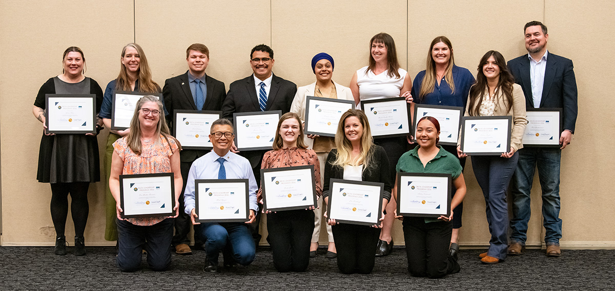 Photo of 14 men and women holding framed certificates