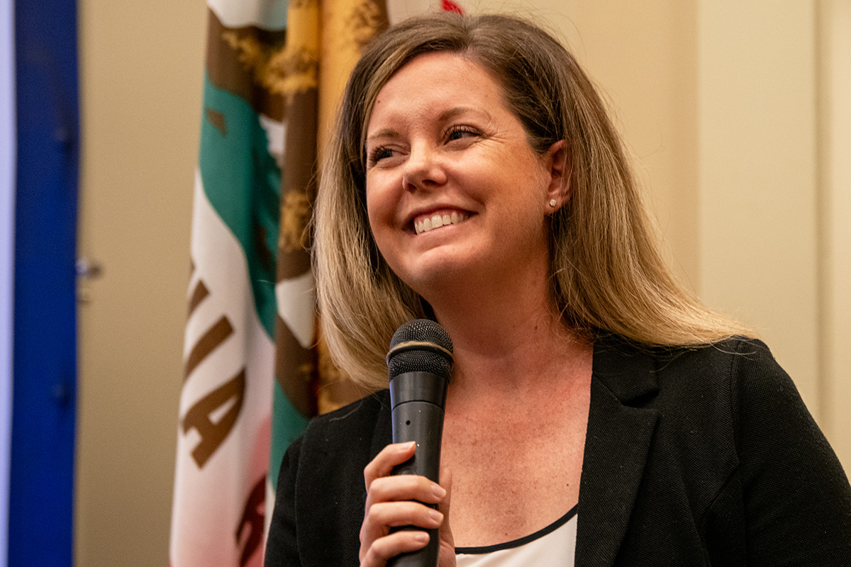 Women smiling while holding a microphone